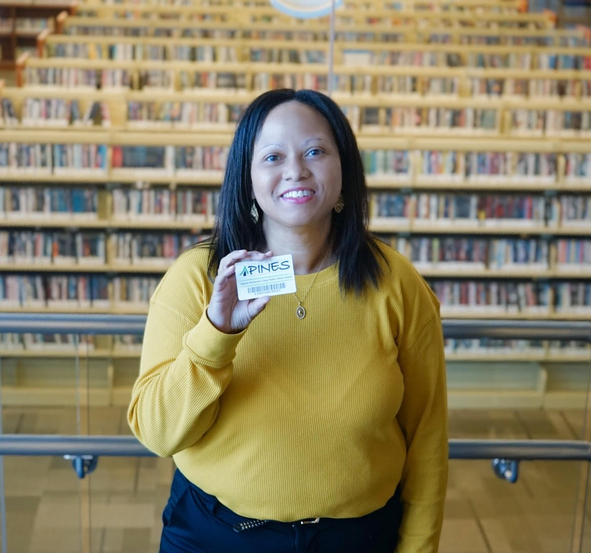 Atira Cotman holding her Pines card the the Augusta Library located on Telfair Street in Augusta, Georgia.